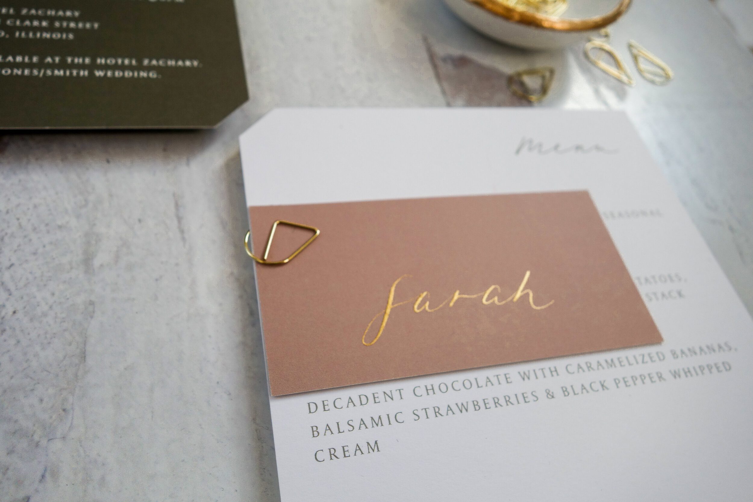 Blush wedding menu card with gold calligraphy on a styled table