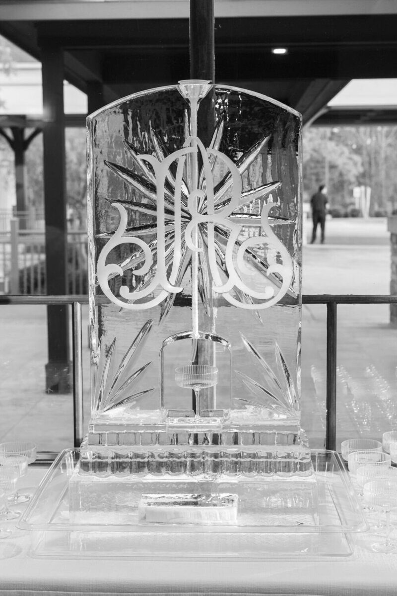 Custom intertwined wedding monogram displayed on a clear ice sculpture at the reception