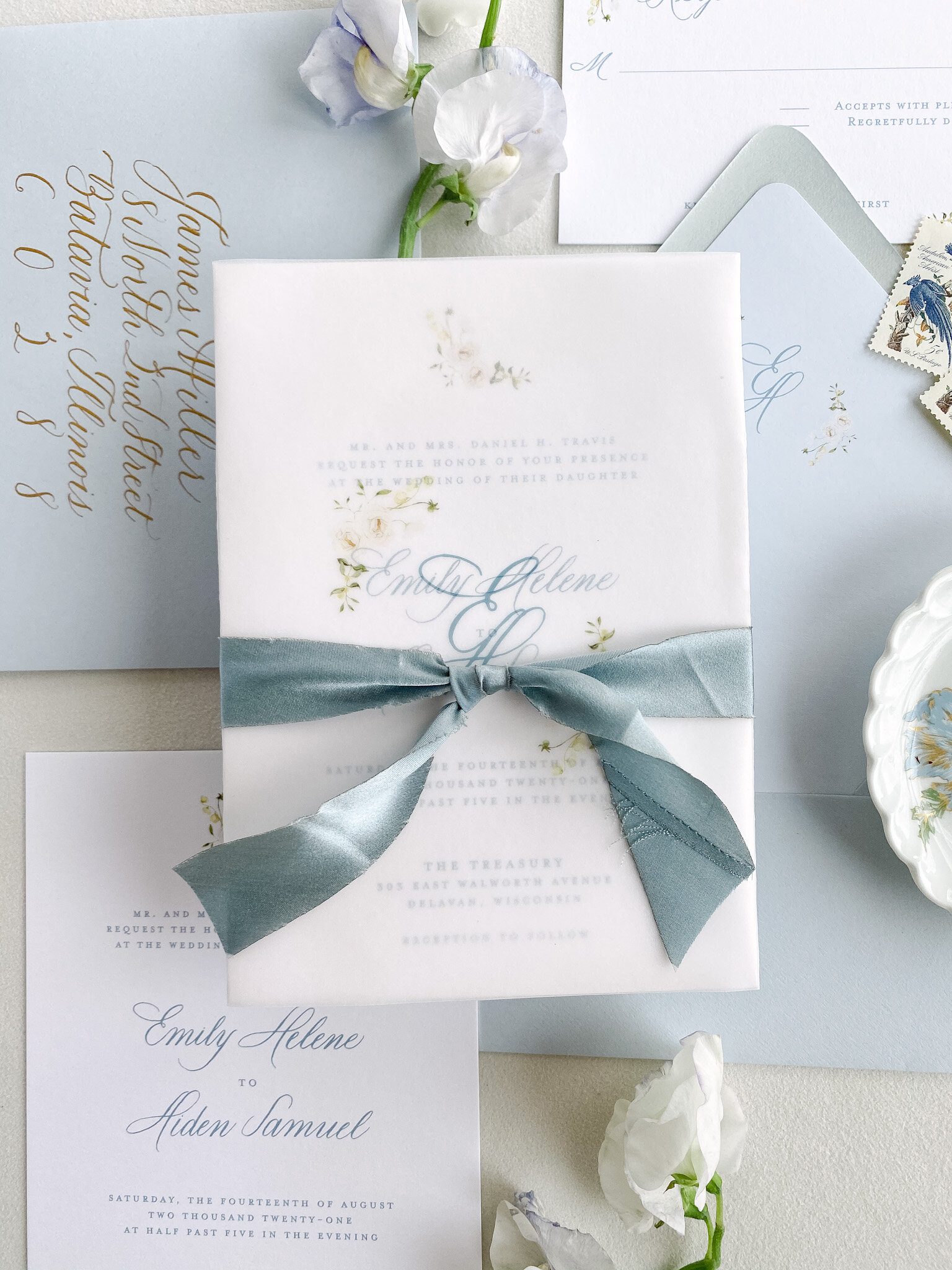 Floral monogram on a vellum wrap tied with green ribbon