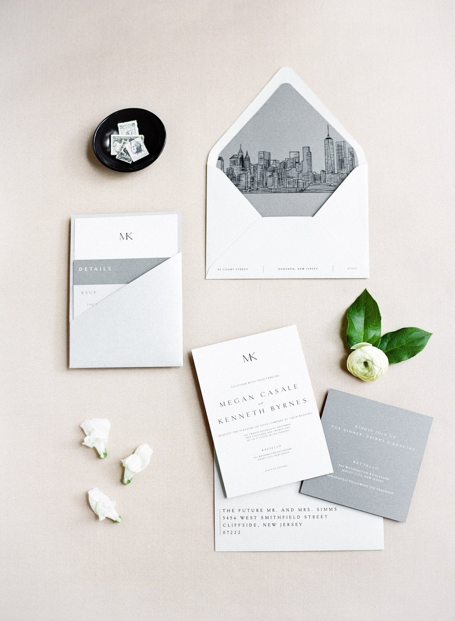 White wedding invitation cards with a gray pocket and wax seal