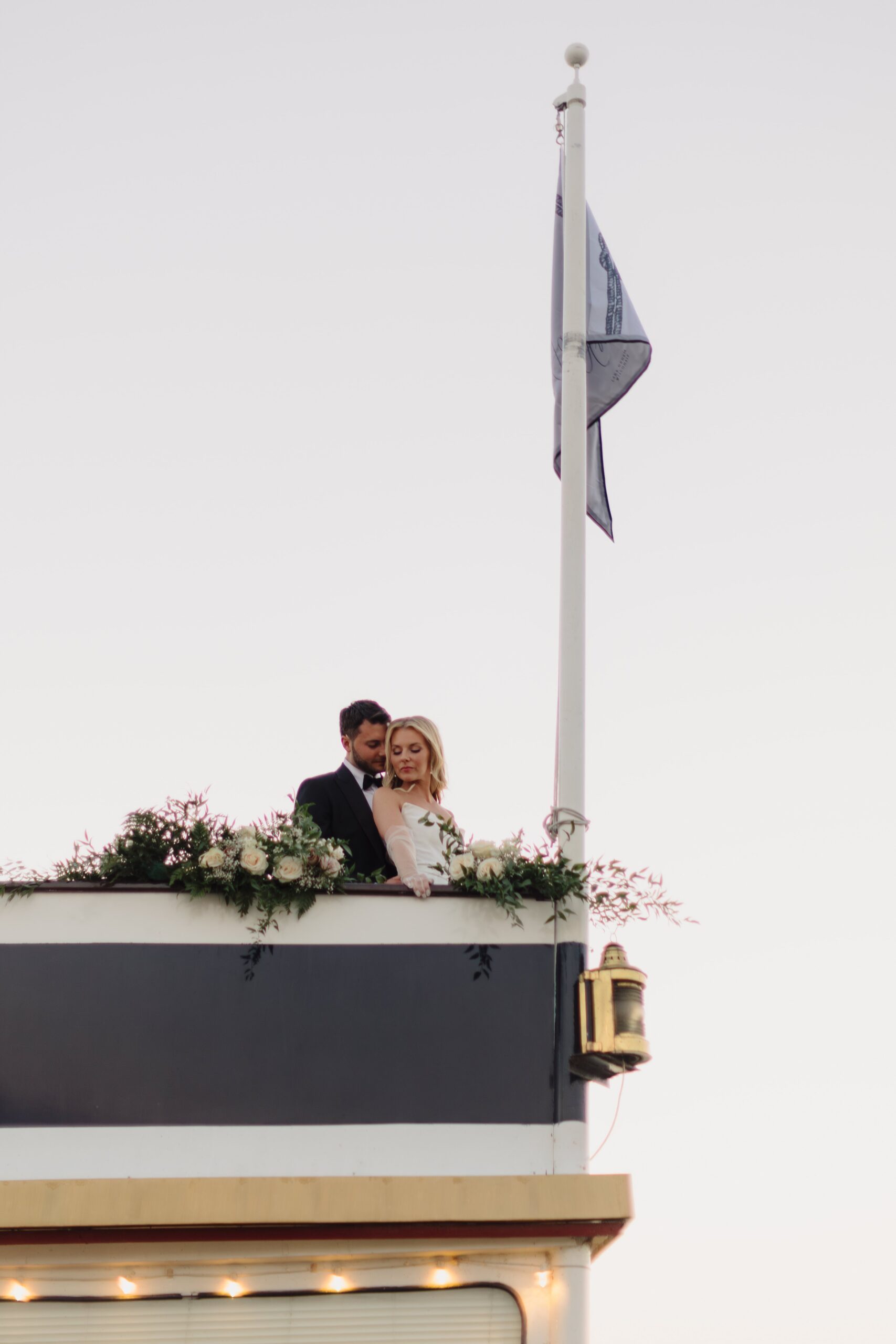 Lakeside wedding cocktail hour with a personalized maritime flag