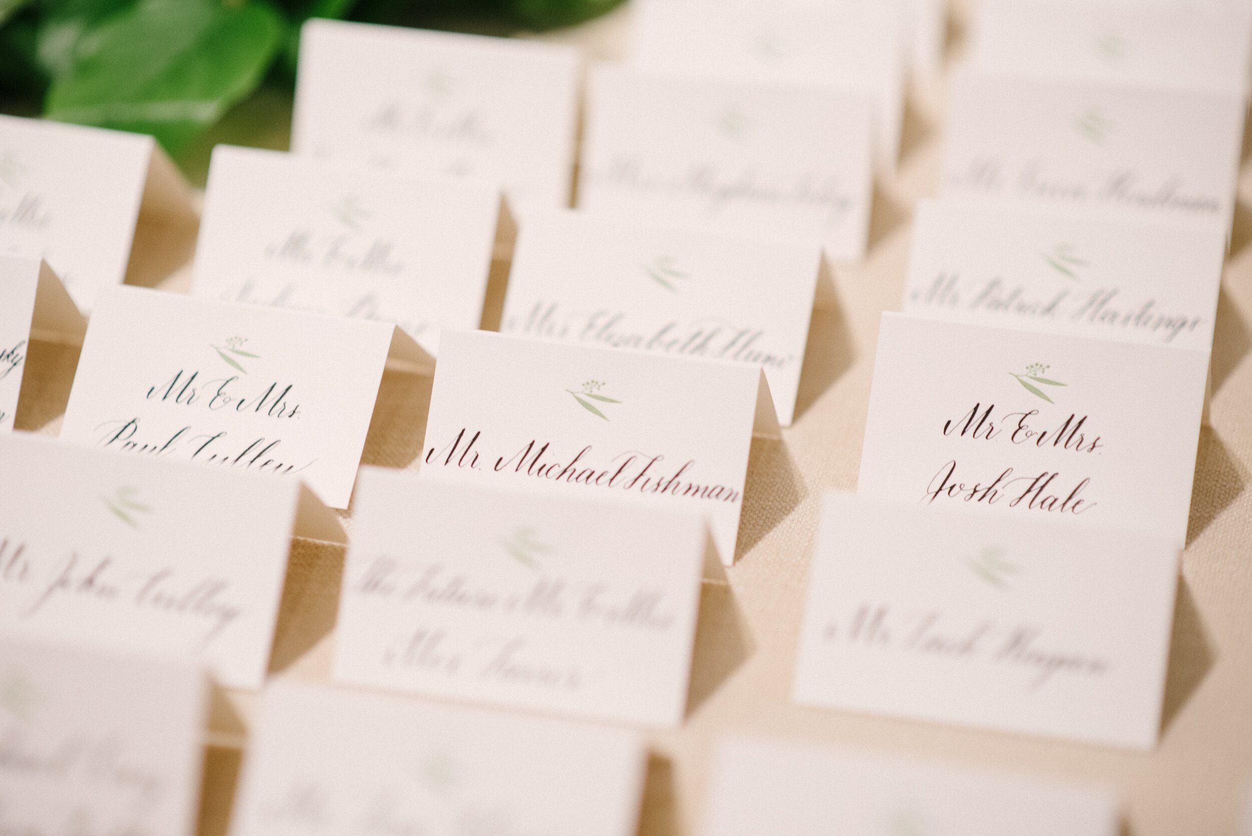 Rows of folded wedding escort cards with calligraphy at Longue Vue Club