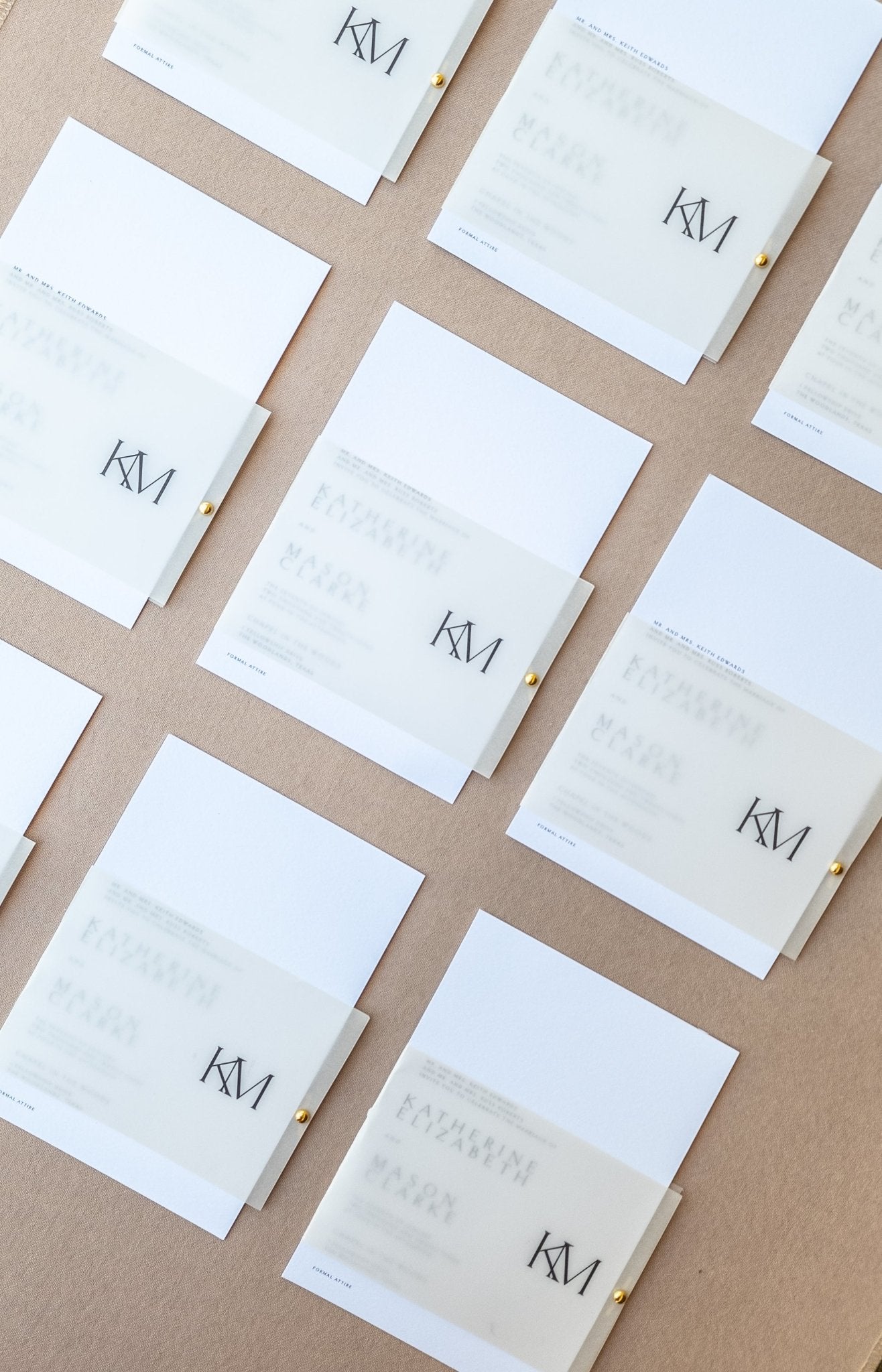 Rows of modern monogram wedding invitations during production