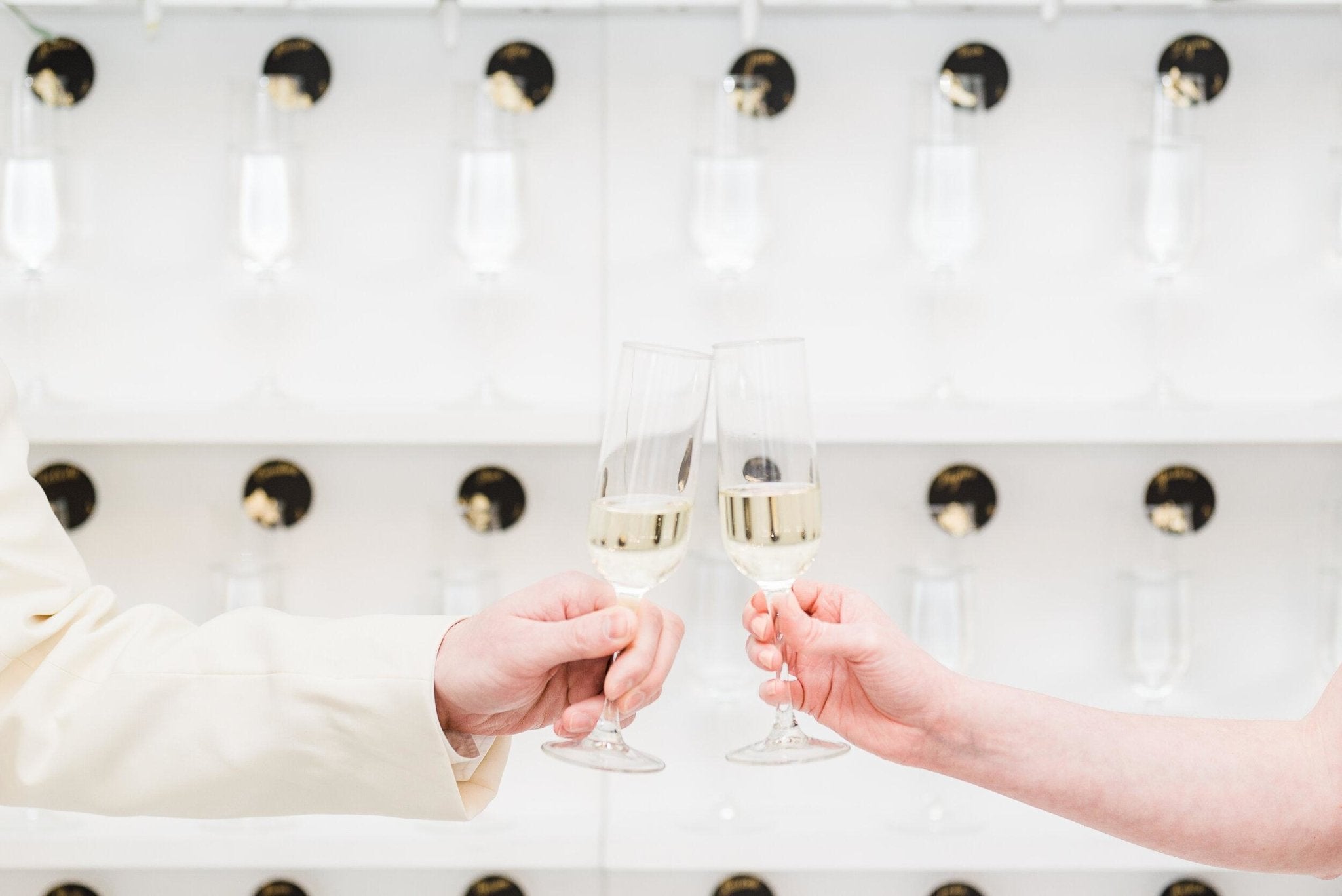 Guests toasting in front of a champagne wall with individual cards at Room 1520