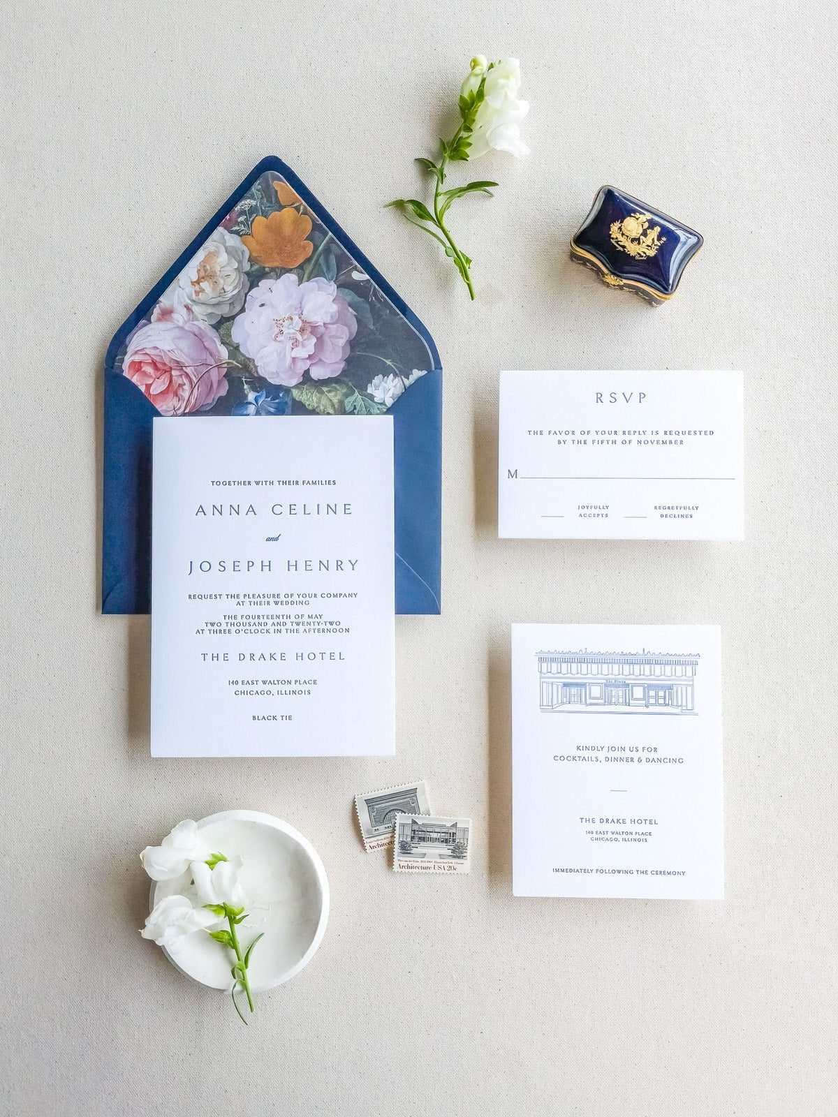 Venue illustration invitation suite with a blue envelope and floral liner