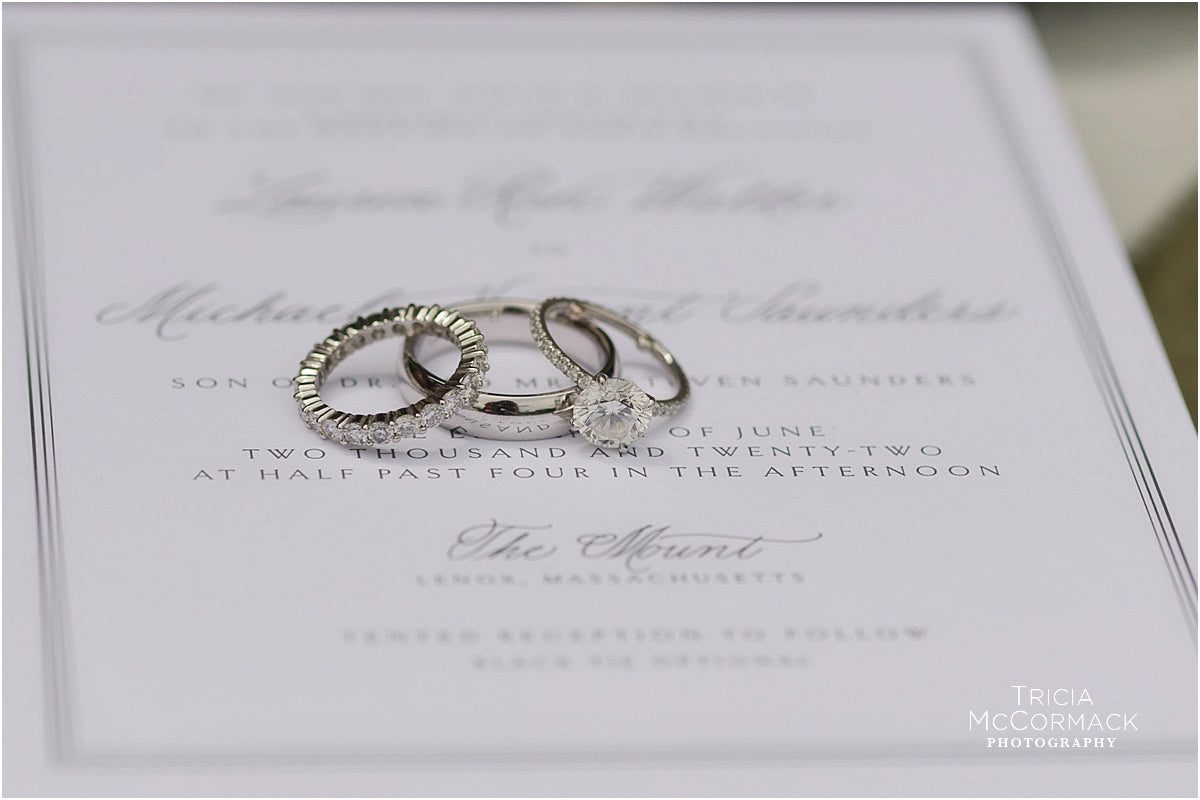 Close-up of invitation lettering with rings resting on the paper
